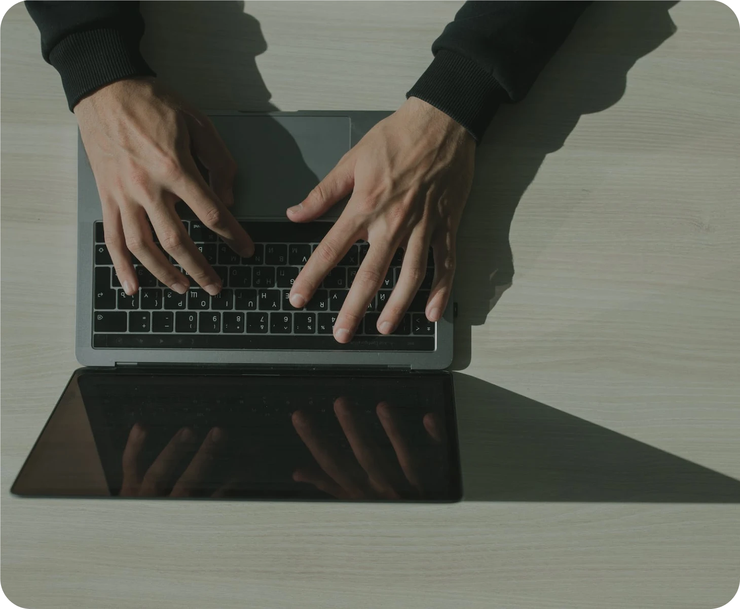 A man typing on a laptop keyboard.